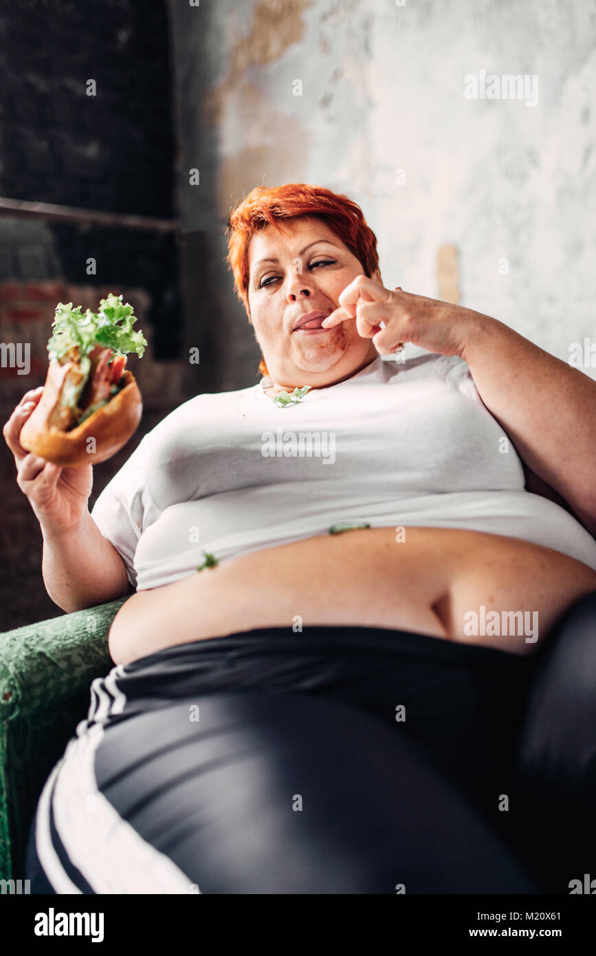 fat-woman-sits-in-a-chair-and-eats-sandwich-overweight-fatty-and-bulimic-M20X61.jpg