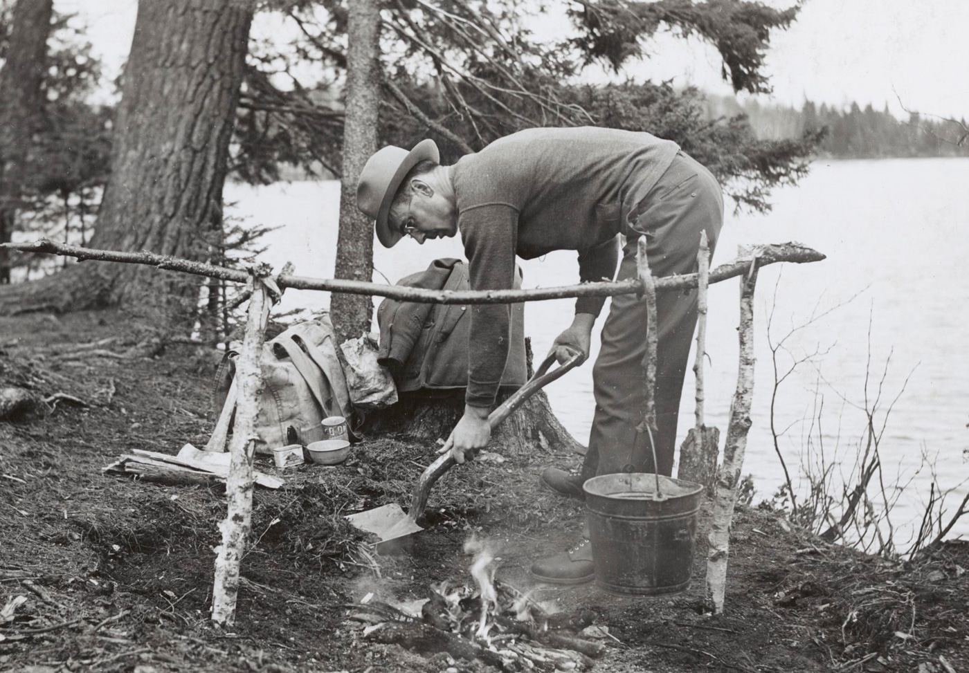 In this 1941 publicity photo, a National Parks ranger demonstrates campfire safety when camping.