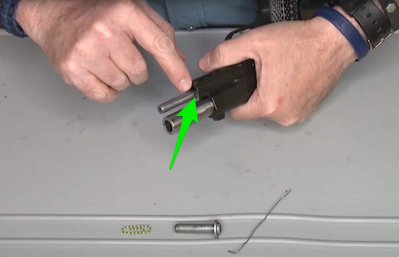 This screen capture is annotated with a green arrow to point to the hole in the full-length guide rod.