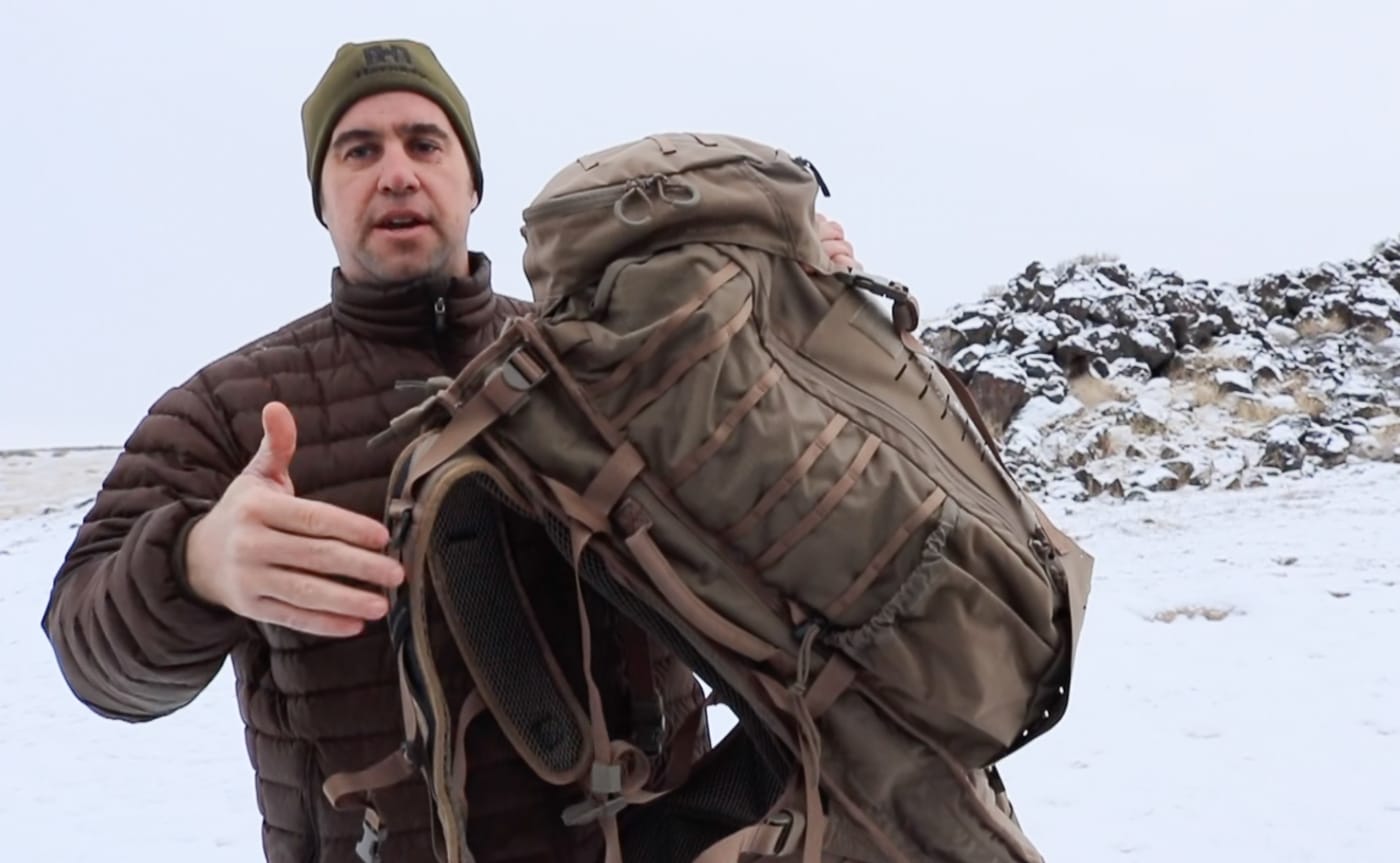A close-up view of the micro MOLLE webbing on the side panel of the Eberlestock Gunslinger 2 tactical backpack. The Eberlestock Gunslinger 2 review examines how side-mounted micro MOLLE adds gear attachment flexibility without increasing bulk. MOLLE compatible pouches and accessories expand a tactical pack's carrying capability in the field. The Gunslinger II uses a slimmer micro MOLLE design on the sides to preserve a streamlined profile during movement. Tactical packs for the SOCOM 16 rifle benefit from modular attachment systems that adapt to changing mission requirements. Side attachment points allow riflemen to distribute smaller items around the pack for balanced weight management. Micro MOLLE reduces overall pack weight compared to traditional full-width webbing systems. Backcountry hunters and tactical users value gear customization options that do not compromise mobility in harsh terrain. A well-placed modular attachment system turns a rifle-carrying backpack into a fully configurable field platform.