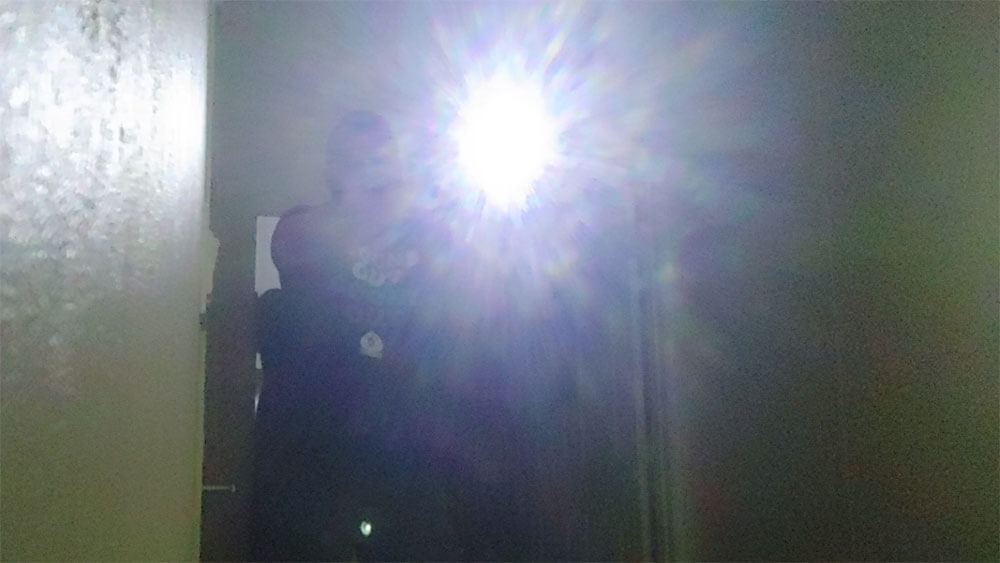 The author demonstrates the blinding power of a bright flashlight in a self-defense situation.