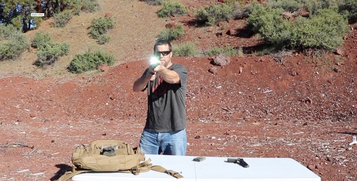 An AR-style pistol with the Viridian X5L mounted on top of the handguard rail instead of the traditional bottom position, showing alternative mounting configuration. The Viridian X5L review explores multi-platform applications. Light and laser unit versatility extends across firearm types. Green lasers function on both pistols and rifles. AR-platform weapons accept standard rail accessories. The X5L mounts to any Picatinny rail system. Top-mounting provides grip indexing benefits. Home defense firearms include various platform options. Combined units adapt to different tactical needs.