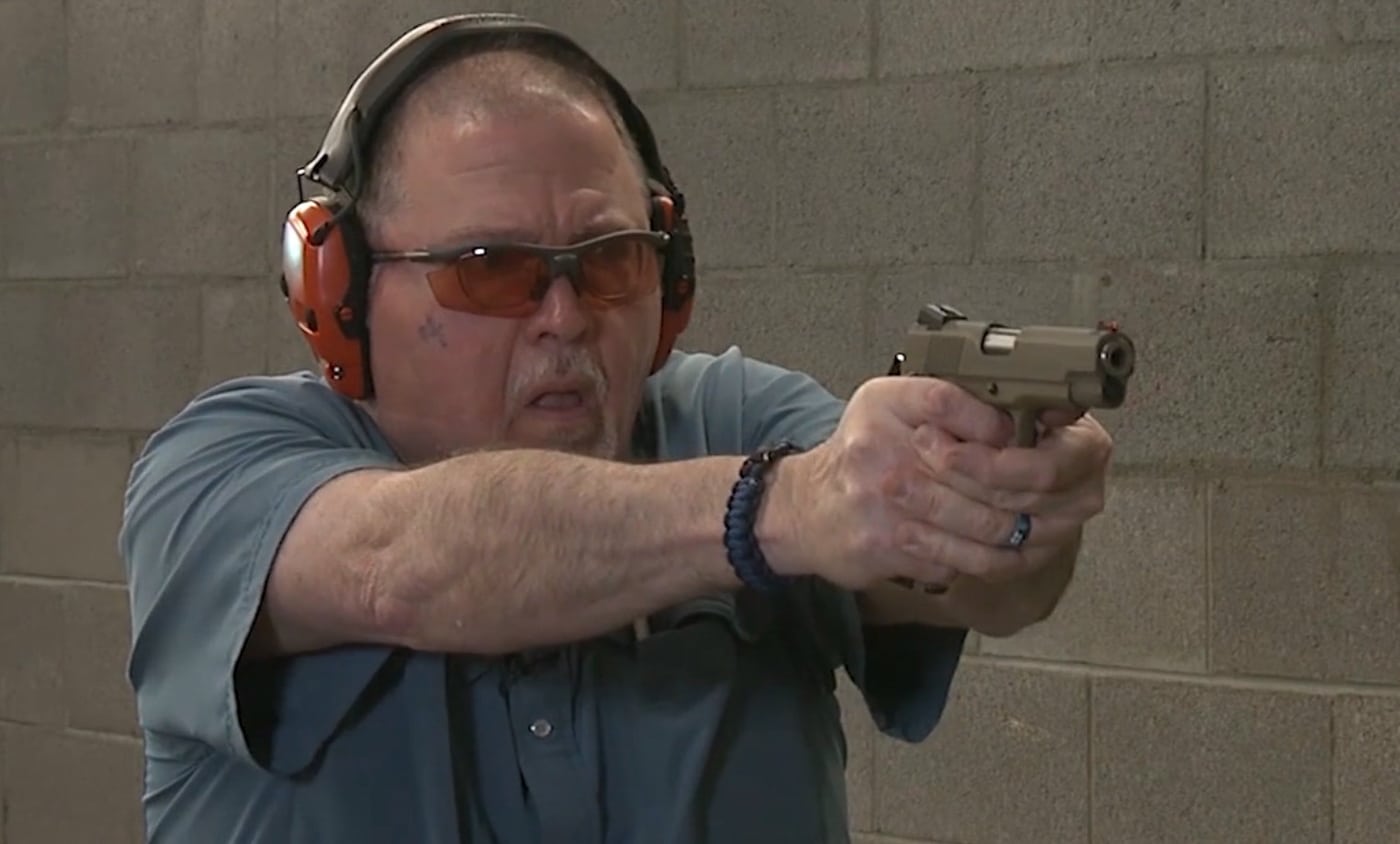 The author stands at an indoor shooting range with the EMP4 extended in a firing stance, demonstrating proper grip and sight alignment during live fire. The EMP4 delivers manageable recoil characteristics. Springfield Armory EMP4 performs well in shooting drills. Compact 1911 pistols offer excellent accuracy potential. The EMP4 stays controllable during rapid fire strings. Mini 1911 designs suit both carry and competition shooting. Springfield's compact pistol provides consistent shot placement. The EMP4 handles mixed ammunition brands reliably.