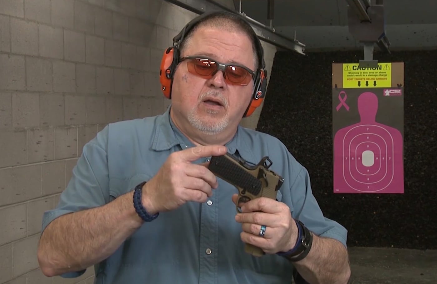 The author's fingers point to the bobbed tail at the base of the EMP4's grip, highlighting the rounded, contoured cut that eliminates the traditional mainspring housing extension. The EMP4 bobbed tail enhances concealed carry capability. Springfield Armory EMP4 features contoured grip design. Compact 1911 pistols benefit from reduced printing under clothing. The EMP4 eliminates sharp grip edges. Bobbed-tail firearms improve carry comfort significantly. Springfield's compact pistol includes deliberate concealment features. The EMP4 maintains grip control despite reduced dimensions.