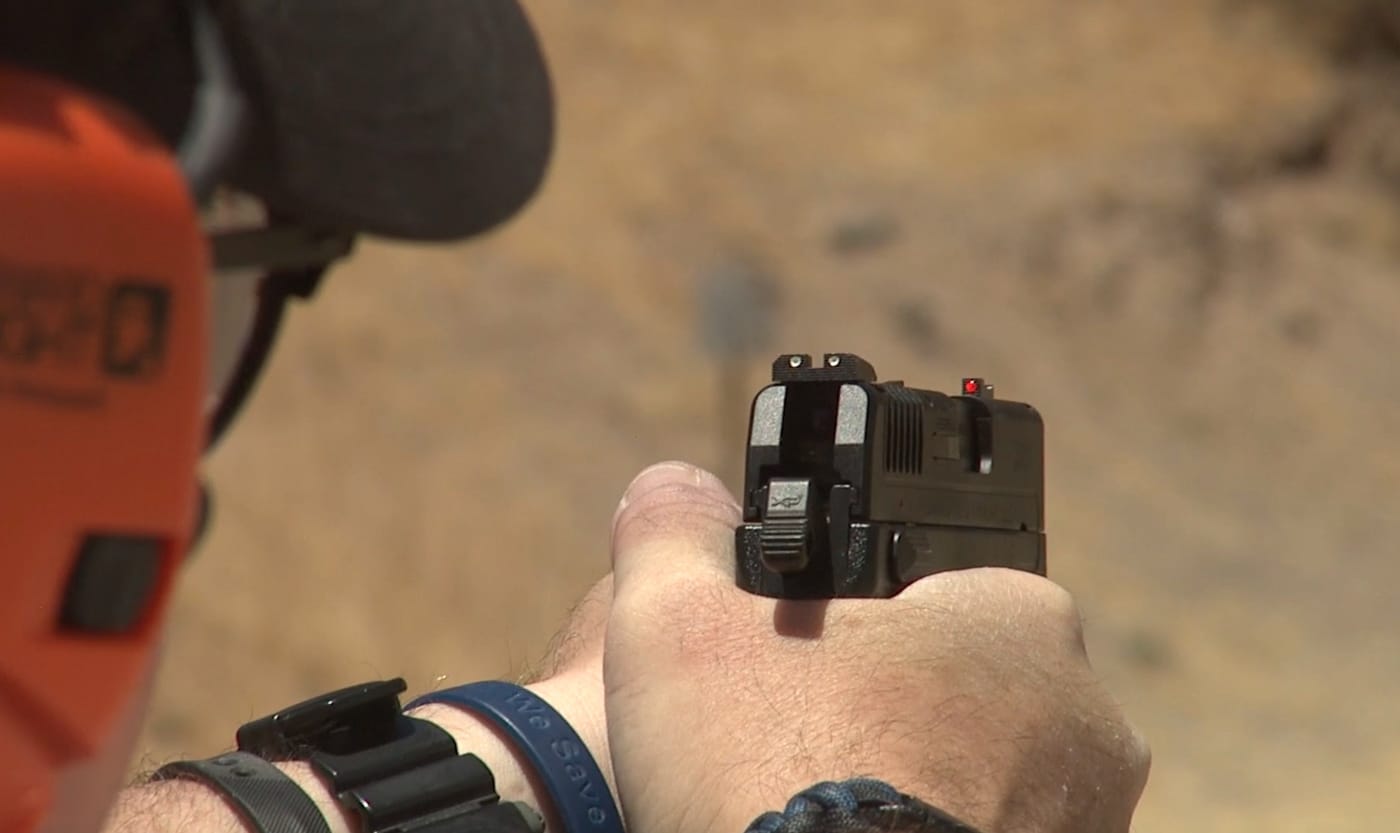 The photograph captures a shooter's hands gripping a Springfield XD-E pistol with finger on trigger immediately after experiencing a failure to fire during range practice. The double strike capability of Springfield XD-E allows shooters to attempt primer ignition twice without manual slide cycling. Author demonstrates proper trigger press technique for second-strike attempts on stubborn or high primers. Springfield Armory XD-E users can diagnose type one malfunctions by attempting immediate follow-up hammer strikes. DA/SA pistols provide tactical advantages during failure-to-fire scenarios through redundant ignition capability. The XD-E hammer system delivers second chances without requiring shooters to break their firing grip. Compact hammer-fired pistols enable double strike responses faster than tap-rack-bang sequences for light strikes. Proper double-action trigger control allows effective second strikes on primers that failed initially. Real-world malfunction response benefits from equipment that offers multiple ignition attempts before manual cycling.