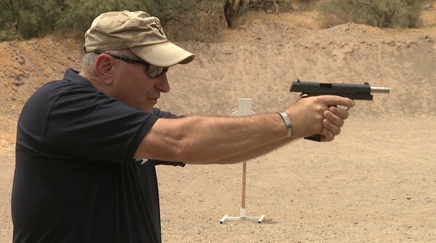 A shooter's handgun displays slide lock during a live fire exercise at a shooting range. Speed reload situations emerge from ammunition exhaustion. Emergency reloading addresses active threat scenarios. Slide lock occurs during magazine depletion. What is a speed reload involves immediate action. Locked slides require fresh magazine insertion. Shooters respond to empty chamber indicators. Threat-active conditions demand rapid responses.