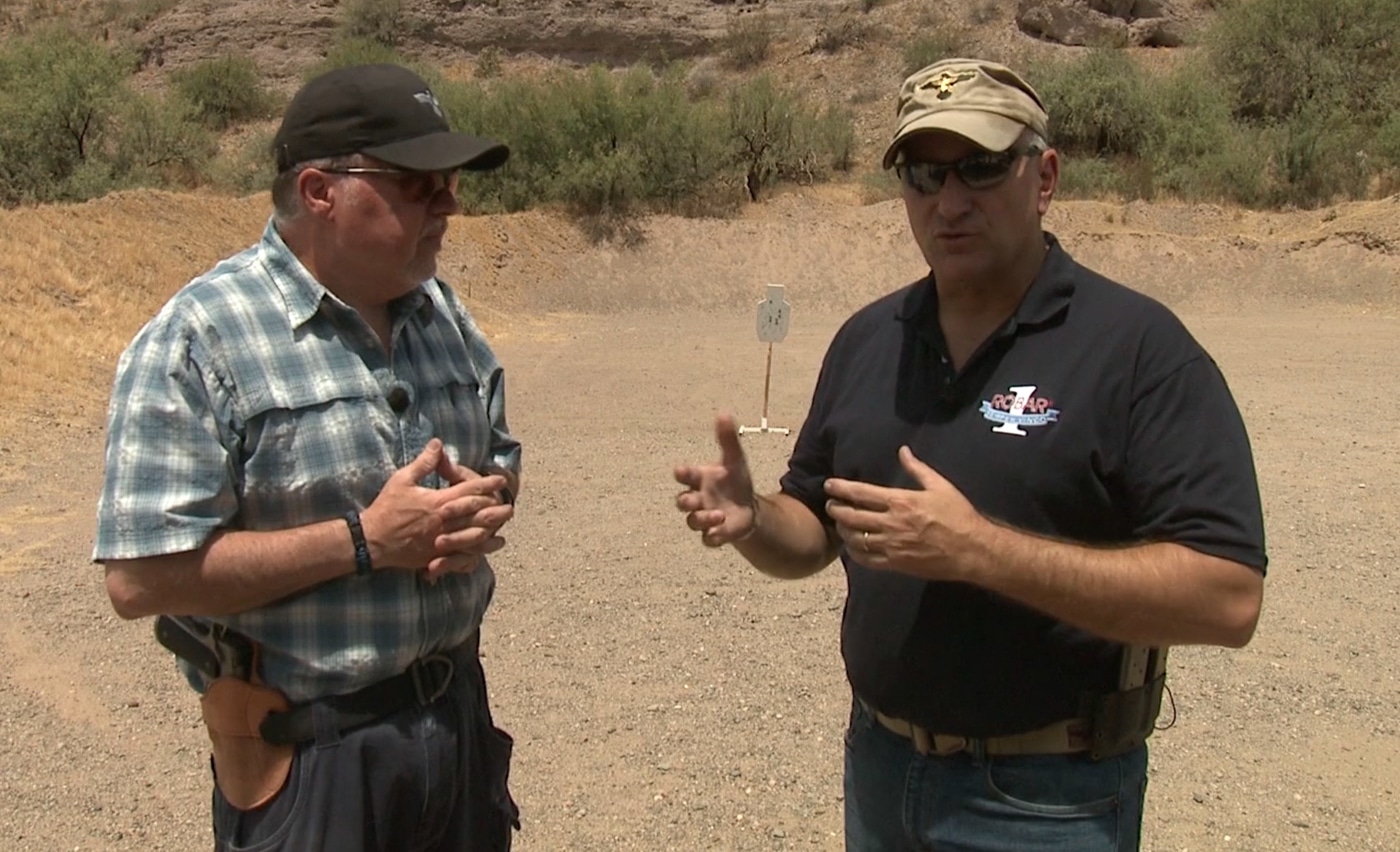 An instructor physically adjusts a student's foot position and body angle while providing hands-on coaching at a shooting range. Learning a shooting stance improves through personalized instruction. Firearms instruction on shooting stances includes real-time feedback. Students develop proper mechanics with guidance. Instructors correct weight distribution errors. Hands-on coaching builds muscle memory. Professional teachers explain recoil management principles. Individual adjustment accelerates skill development. Quality instruction produces consistent shooters.