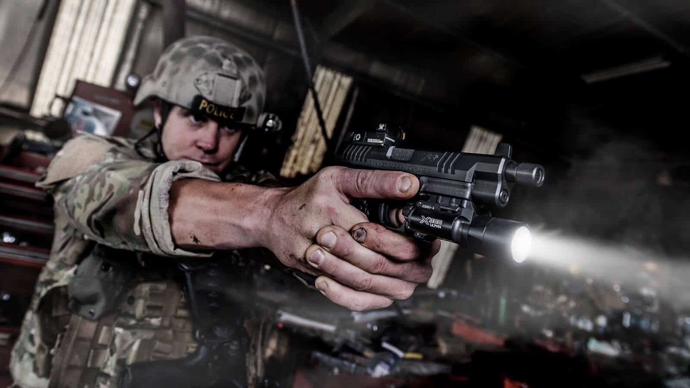 A shooter demonstrates proper foot placement and body positioning on an outdoor shooting range. Learning a shooting stance requires understanding balance and recoil control. Firearms instruction on shooting stances emphasizes athletic positioning. Proper stance supports accurate pistol shooting. Body mechanics affect follow-up shot speed. Forward weight distribution manages muzzle rise. Knee flexion provides stability during firing. Shooters benefit from professional stance coaching. Good fundamentals improve marksmanship outcomes.
