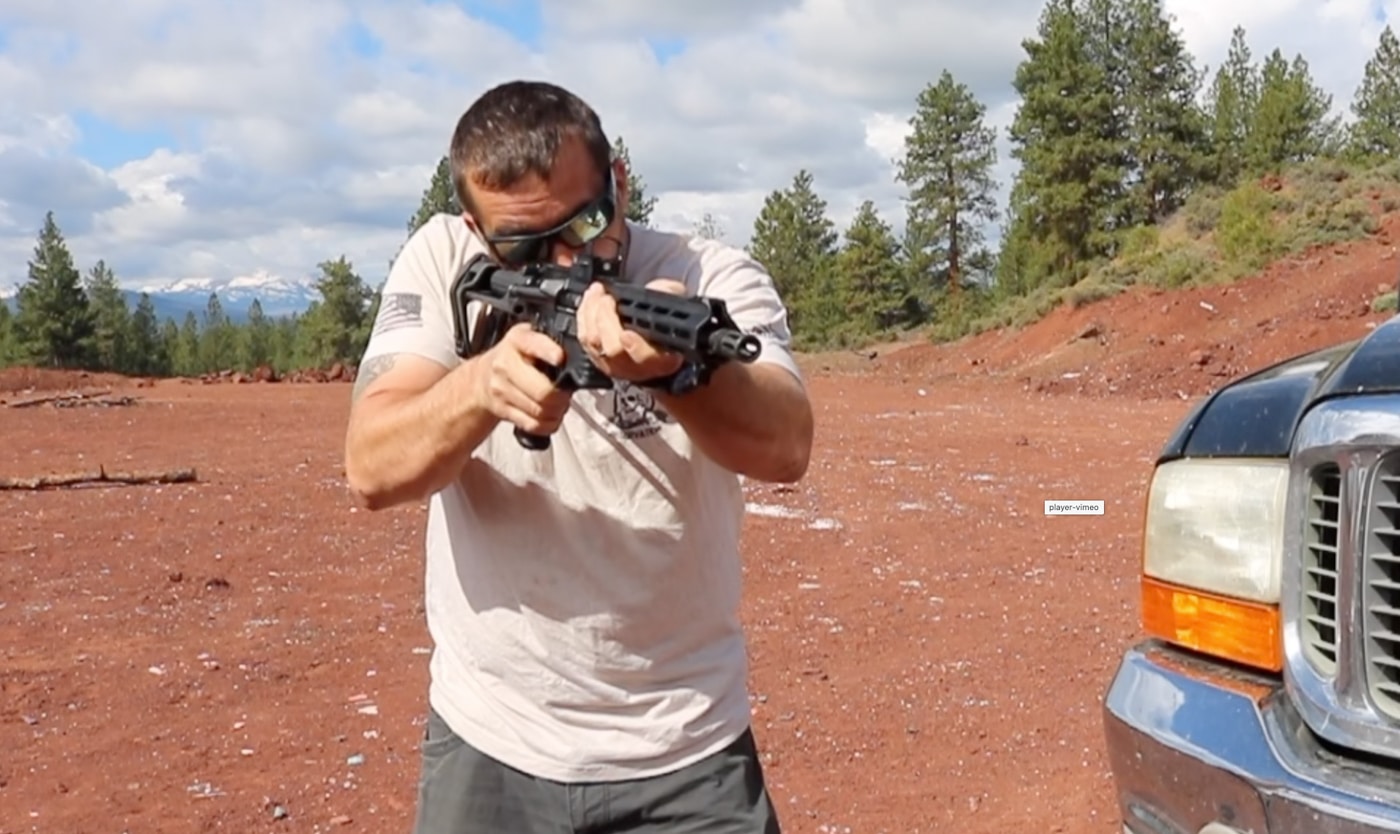 sighting a target with the Bushnell First Strike red dot sight during testing on the shooting range