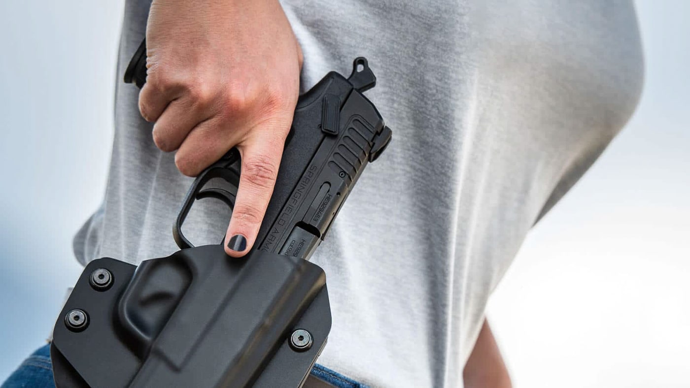 A shooter practicing one-handed pistol manipulation techniques at an indoor or outdoor shooting range. One handed malfunction clearance requires dedicated practice. Clearing pistol jam with one hand builds essential skills. Defensive shooters need backup techniques. Single-hand firearm operation addresses injury scenarios. Pistol users benefit from constraint-based training. Handgun malfunction drills improve readiness. Self-defense preparation includes limited-mobility techniques. Practical shooting skills extend beyond two-handed fundamentals.