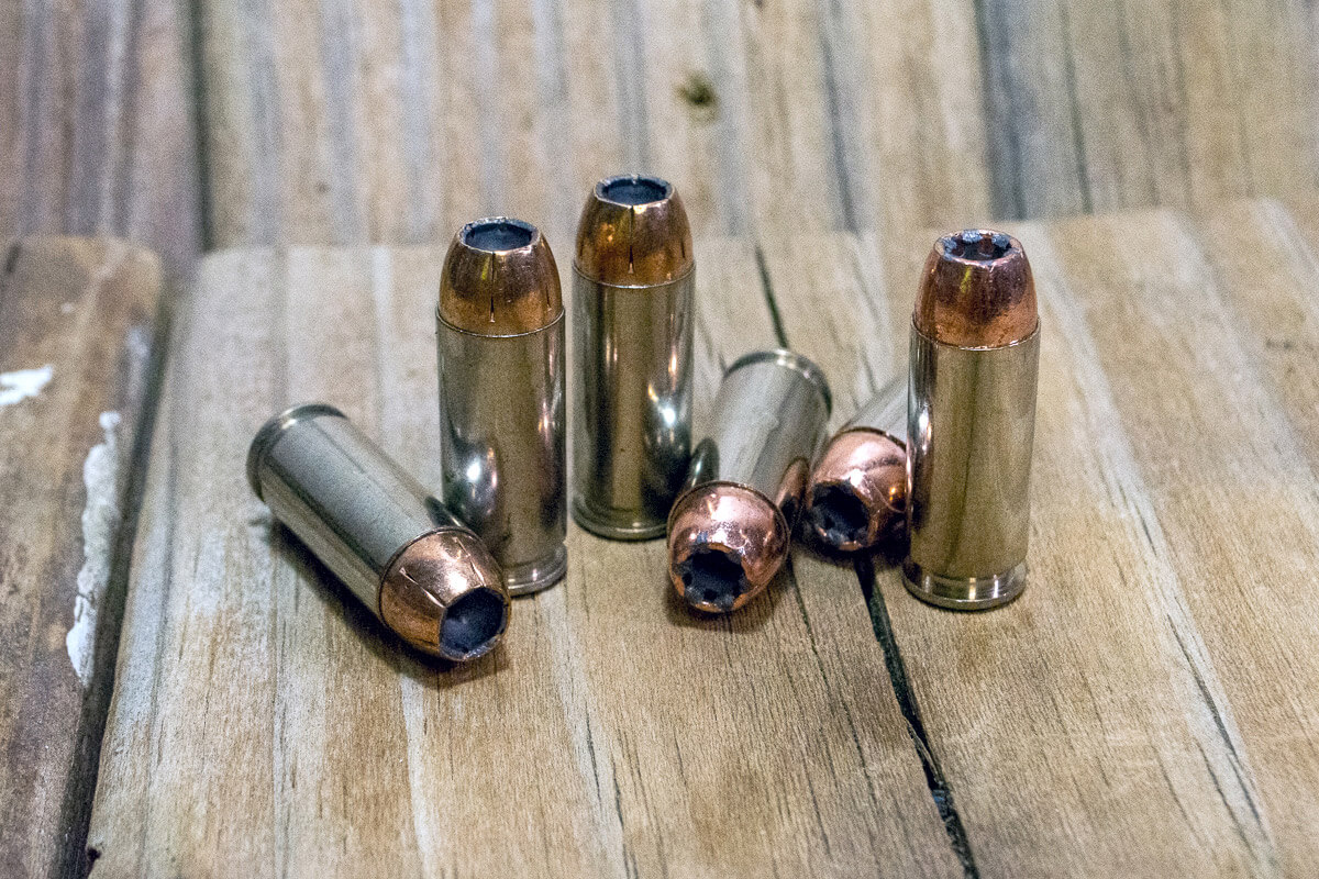 10mm hollowpoint ammunition on a bench