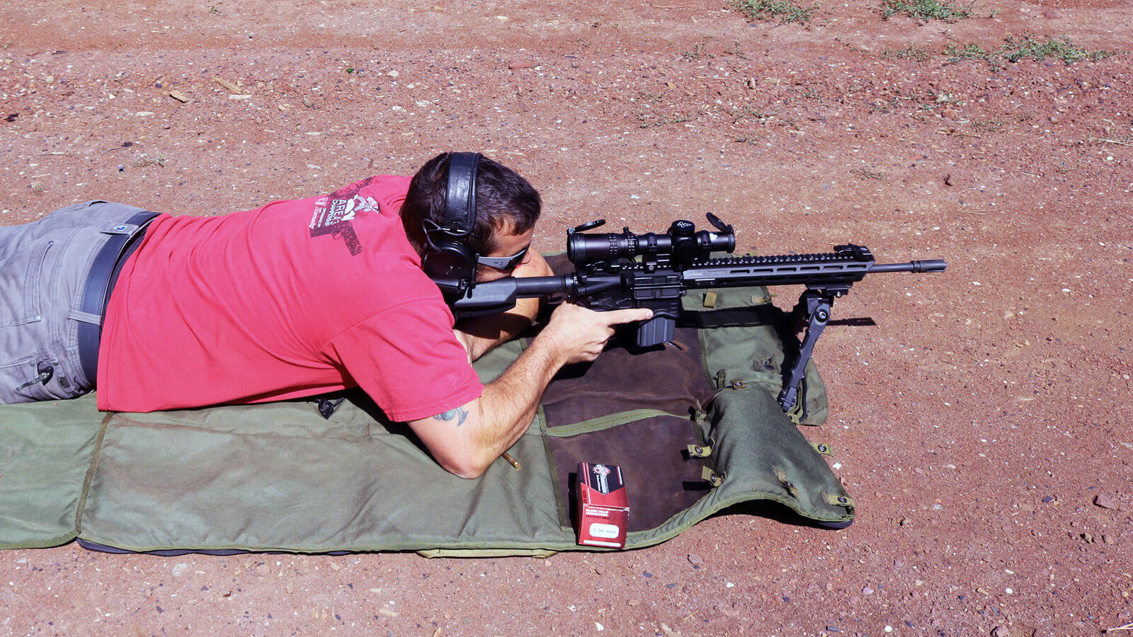The author in a prone shooting position at a shooting range, carefully evaluating the performance of the Nightforce ATACR 1-8x24 telescopic sight on a Springfield Armory SAINT rifle. The shooter aligns the rifle’s reticle with distant targets, testing the optic's magnification range and ED glass for clarity and accuracy. The riflescope’s advanced features, including windage and elevation adjustments, are demonstrated in a practical field environment. This image highlights the versatility of the ATACR series for tactical rifle scopes and AR-15 platforms, suitable for precision rifle shooting and competition. The prone position emphasizes stability and focus, showcasing the practical application of the scope’s technology in real-world scenarios.
