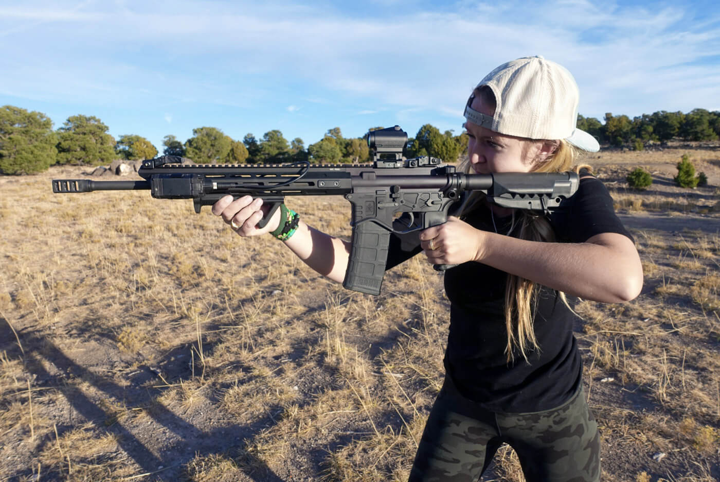 In this photograph, the author is on the shooting range with her AR-15 rifle chambered in 5.56x45mm NATO cartridge.