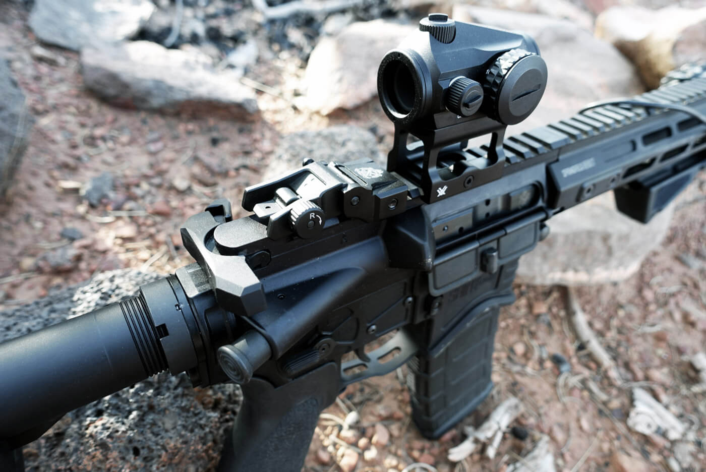Here we see a red dot sight mounted to the top of the rifle using the M1913 Picatinny rails. The iron sights are also visible.