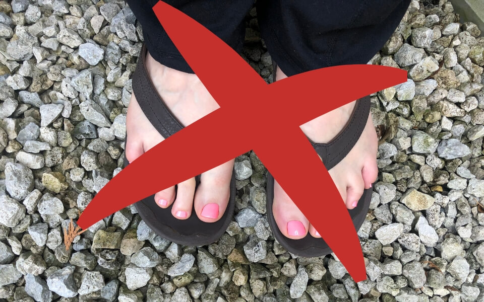 wearing black flip-flops at the shooting range with exposed toes Woman wearing flip-flops on the shooting range. The flip-flops are black and she has pink toe nail polish. These are not a good choice for wearing at the shooting range.