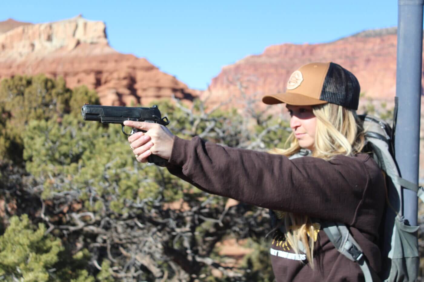 Blonde woman shooting a 1911 chambered for the 10mm cartridge