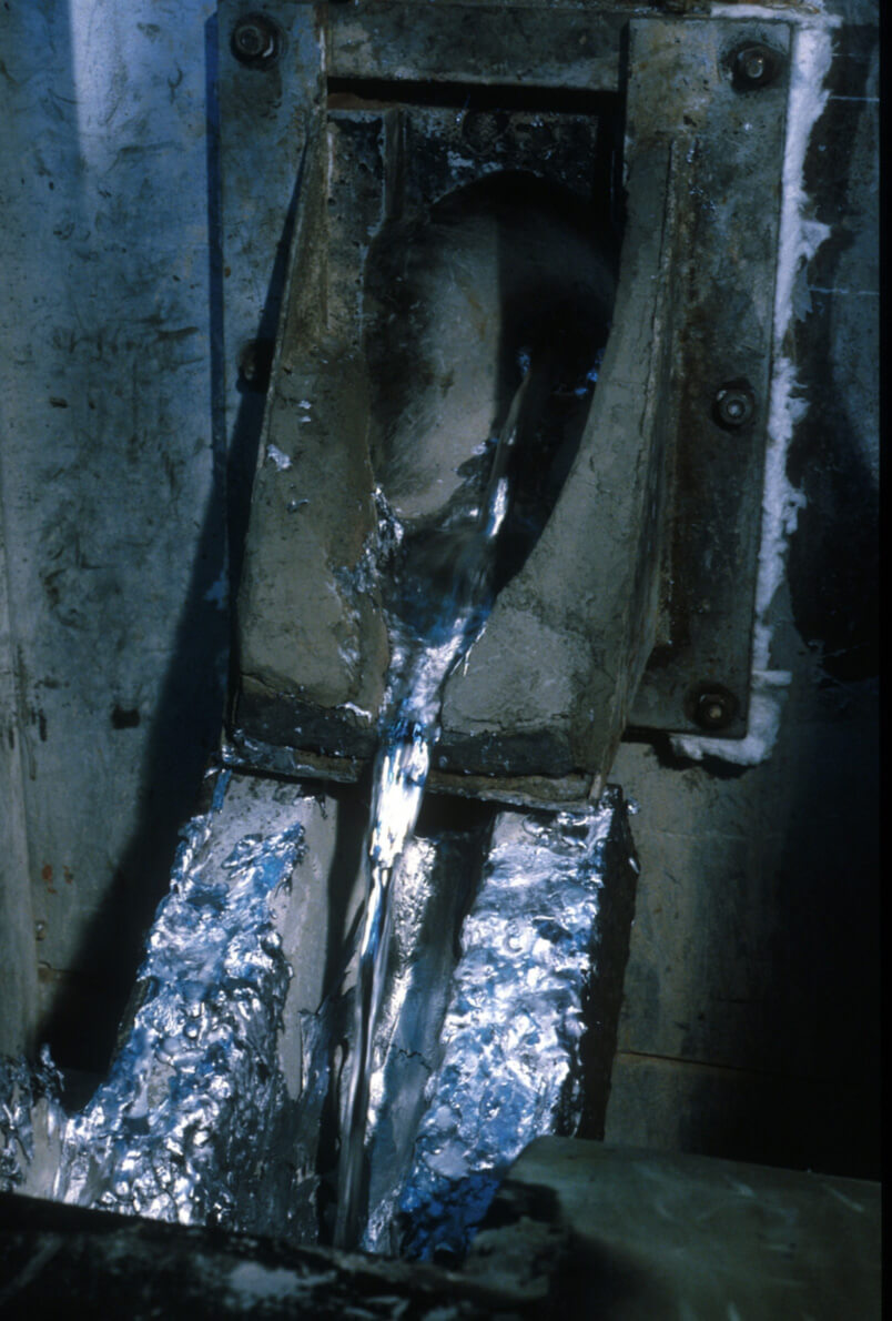 In this digital image, we see molten steel being poured into a cast to manufacture a gun frame.  The casting process is an excellent process for a strong alloy. Precise craft, steel casting is. Molten steel, in a die, meticulously poured, solidifies into forms complex and rigid. Suited for firearm components that withstand high stress, the process is. Careful control of temperature and composition, a metallurgist requires, ensuring the integrity and performance of weapons grade. Especially for receivers and frames, utilized it often is; the backbone they form of the firearm's strength. Burdened with the purpose of enduring explosive pressures, these parts, casting them often sees the addition of chromium or nickel, strength and corrosion resistance to enhance. In specifying methods and materials, guided by knowledge of how metal alloys cope under duress, one is. A careful combination of science and craftsmanship, critical for ensuring safeties proprieties of firearms, steel casting remains.