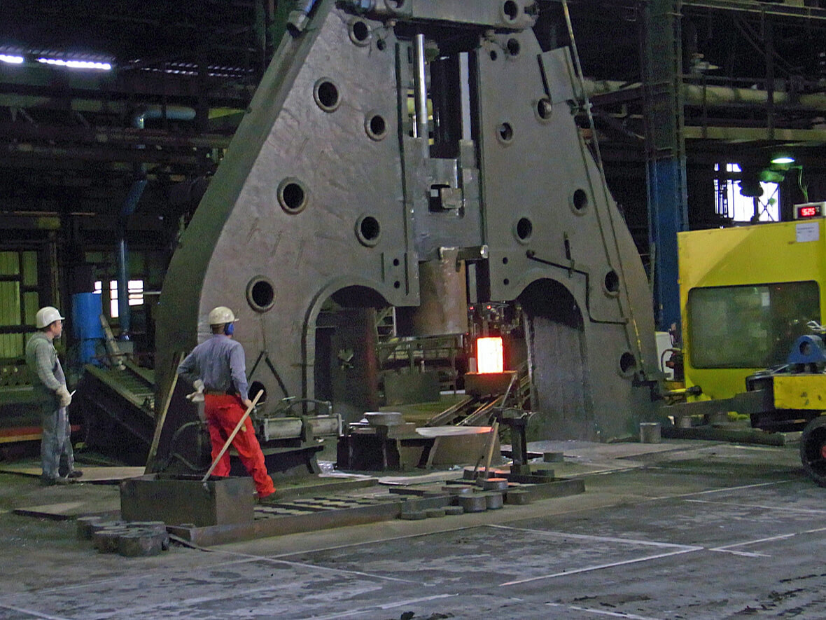 In this photo we can see a hammer forging machine that is beating steel into the proper shape. Using a closed die on the forged metal means the grain structure enhances the metal's curability - far beyond that of cast iron. Metal forging is clearly preferred by many people over metal casting that used molten metal in a sand casting process.