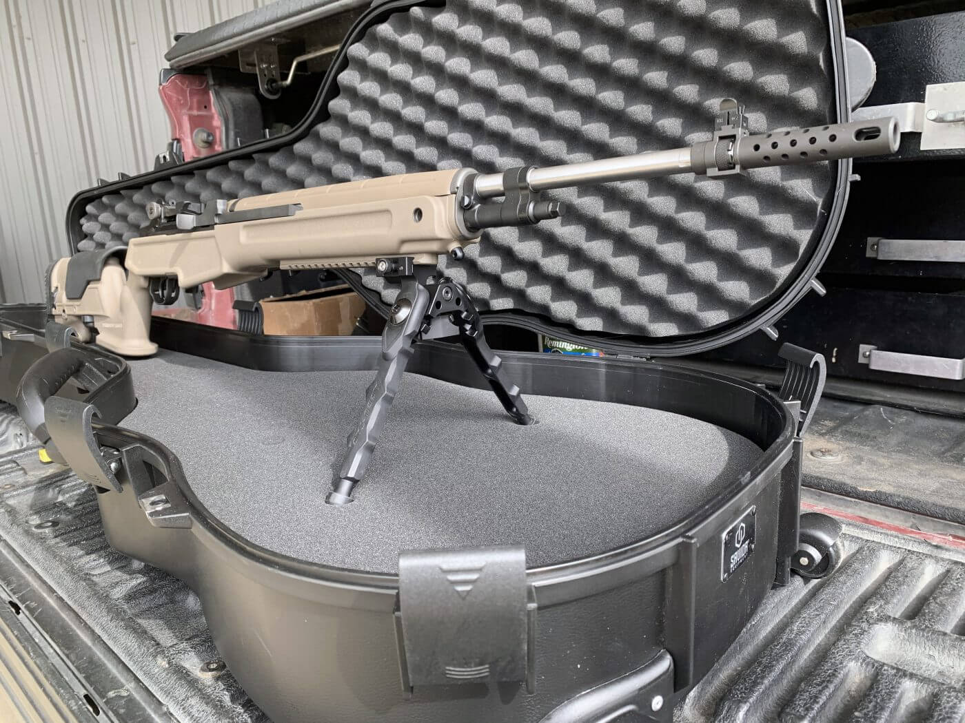 testing the iron sights on the semi-automatic rifle at the shooting range This photo shows the Springfield firearm chambered for the 6.5 Creedmoor cartridge. It is shown in a gun case at the shooting range. It is equipped with a muzzle brake on the rifle barrel.