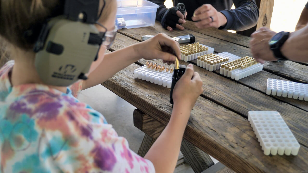 Child loading handgun magazine with 9mm ammo from Federal