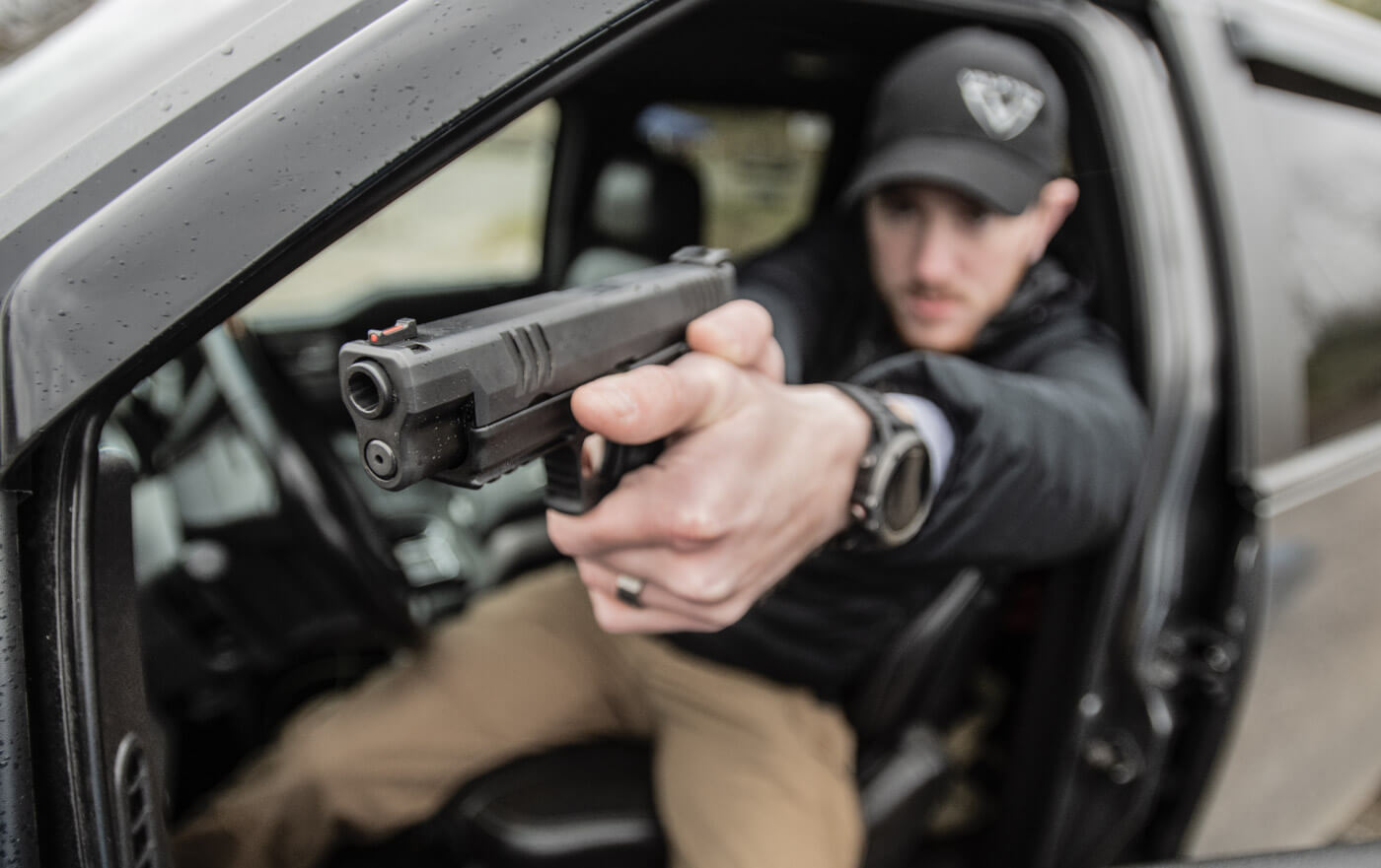 Police officer shooting a 10mm Springfield XD-M from his patrol car