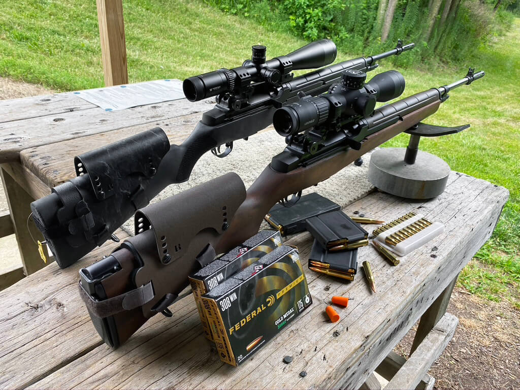 In this photograph, the author shows us two of her M1A rifles - one in 308 and the other in 6.5 Creedmoor - with the cheek rests she was testing.