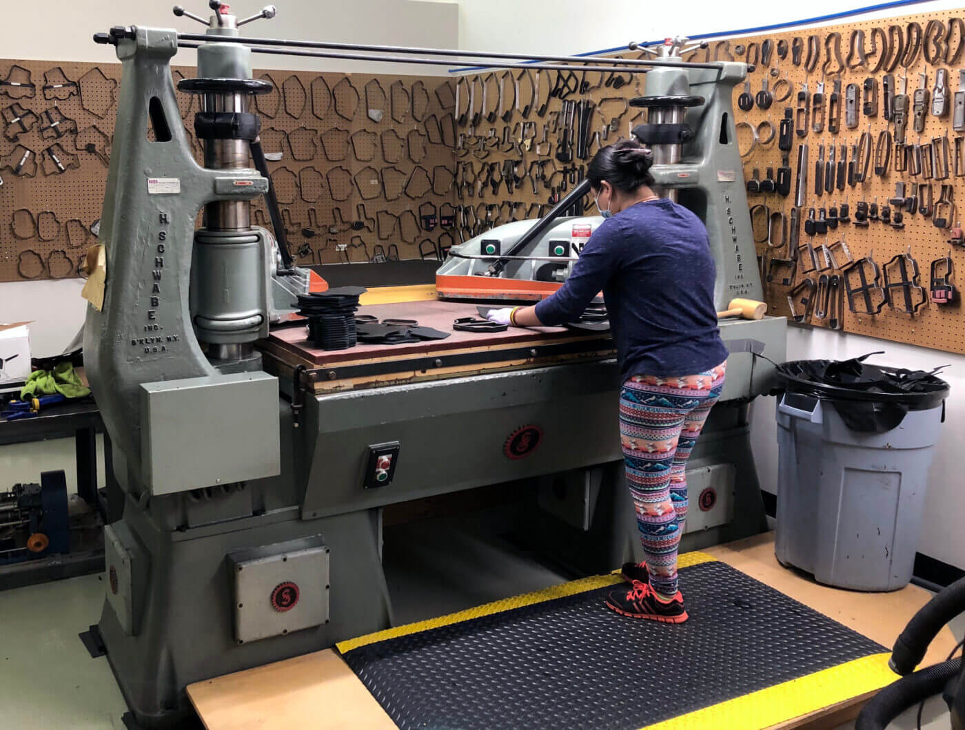 A man and a woman work side by side in the Mitch Rosen factory, meticulously crafting holsters. The scene showcases tools, leather, and machines, highlighting the process of creating Mitch Rosen holsters. This dedication to leather craftsmanship for holsters reflects the brand's commitment to producing durable leather holster materials. The photo captures the artistry behind handcrafted gun holsters and premium concealment accessories.