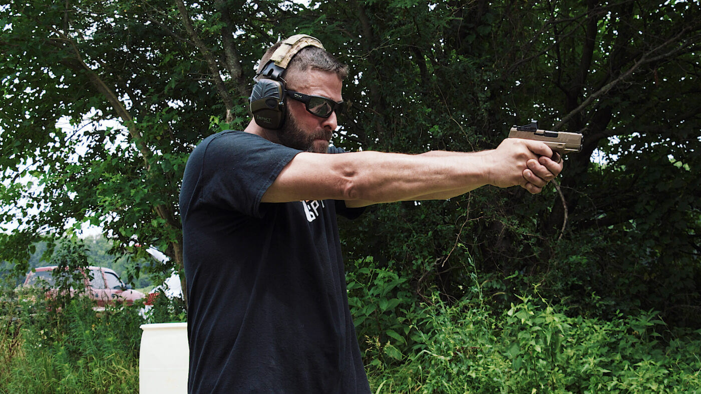 Side view of author with Hellcat handgun at extension