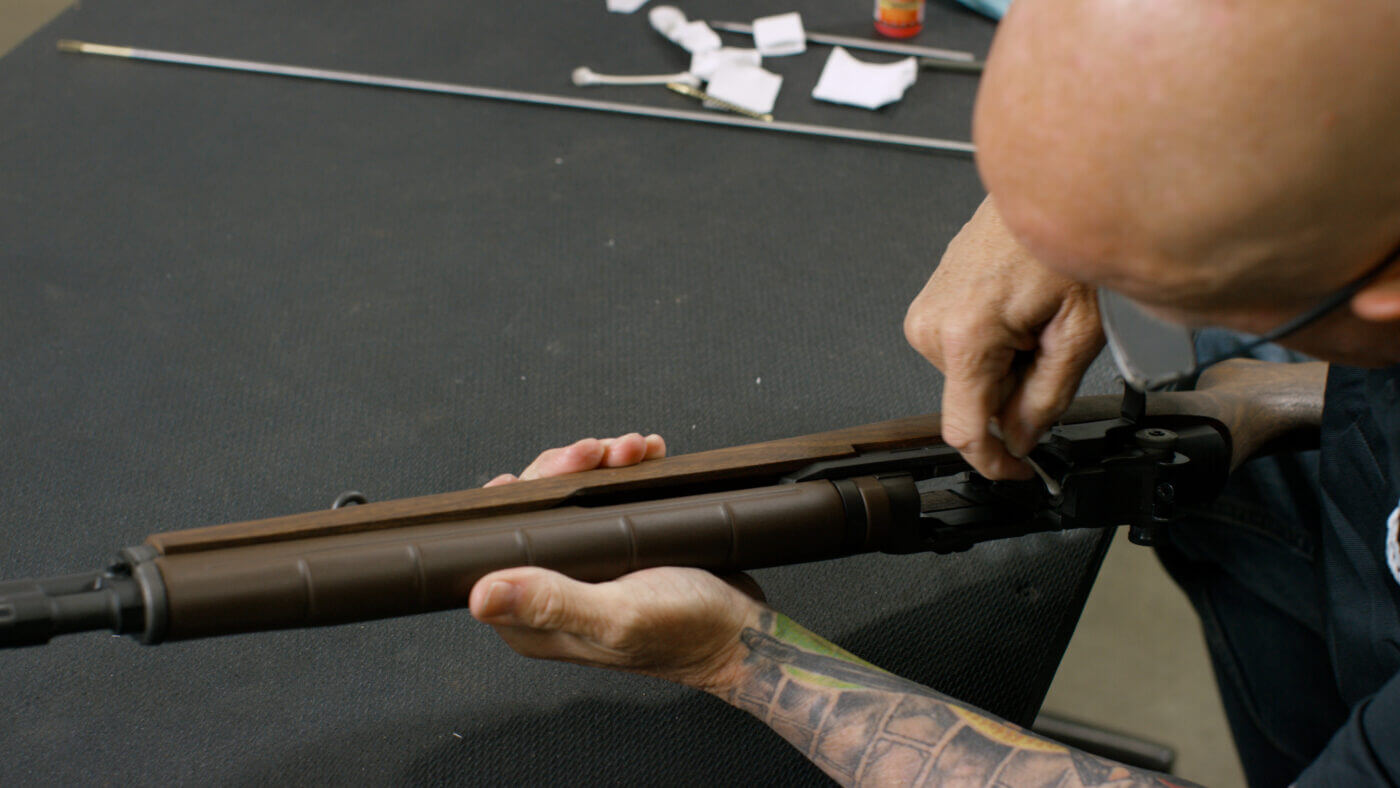 Cotton swab cleaning the bolt face of an M1A