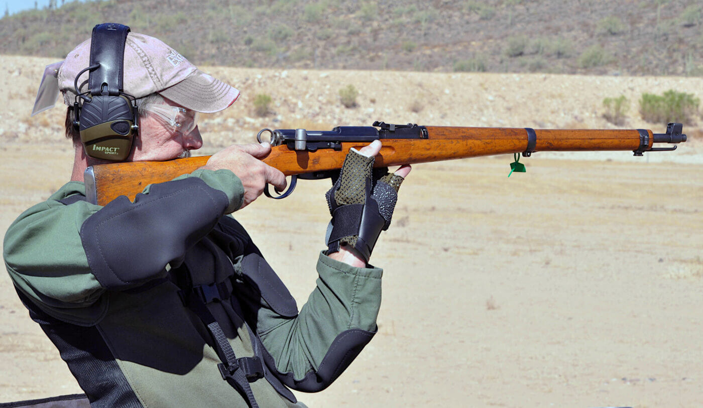 The author fires a Swiss K31 rifle from an offhand position during a Vintage Military Rifle Games match. The precision and craftsmanship of the K31 are evident as the shooter demonstrates skill and control. The match setting reflects the emphasis on historical accuracy and traditional shooting techniques. This image embodies the essence of the Vintage Military Rifle Games, where history and marksmanship come together in competition.