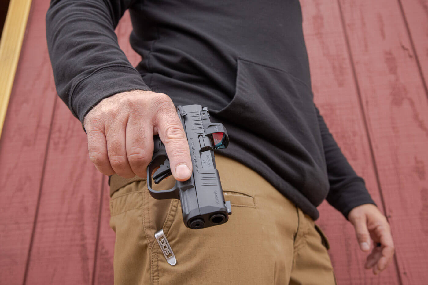 Man carrying a Hellcat pistol in his right hand