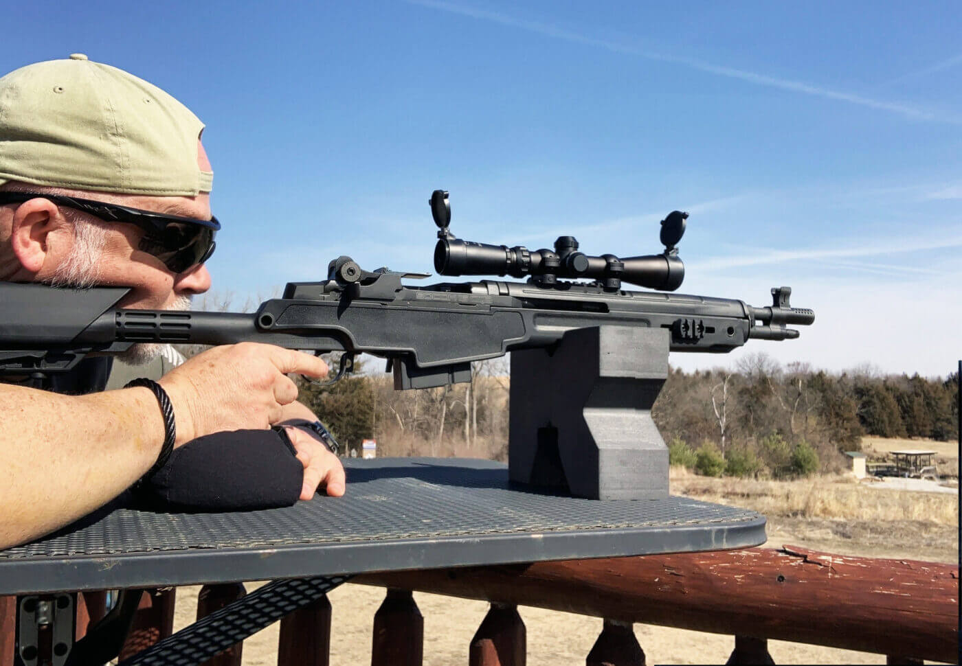 Man shooting rifle with scout scope on M1A SOCOM 16 CQB rifle