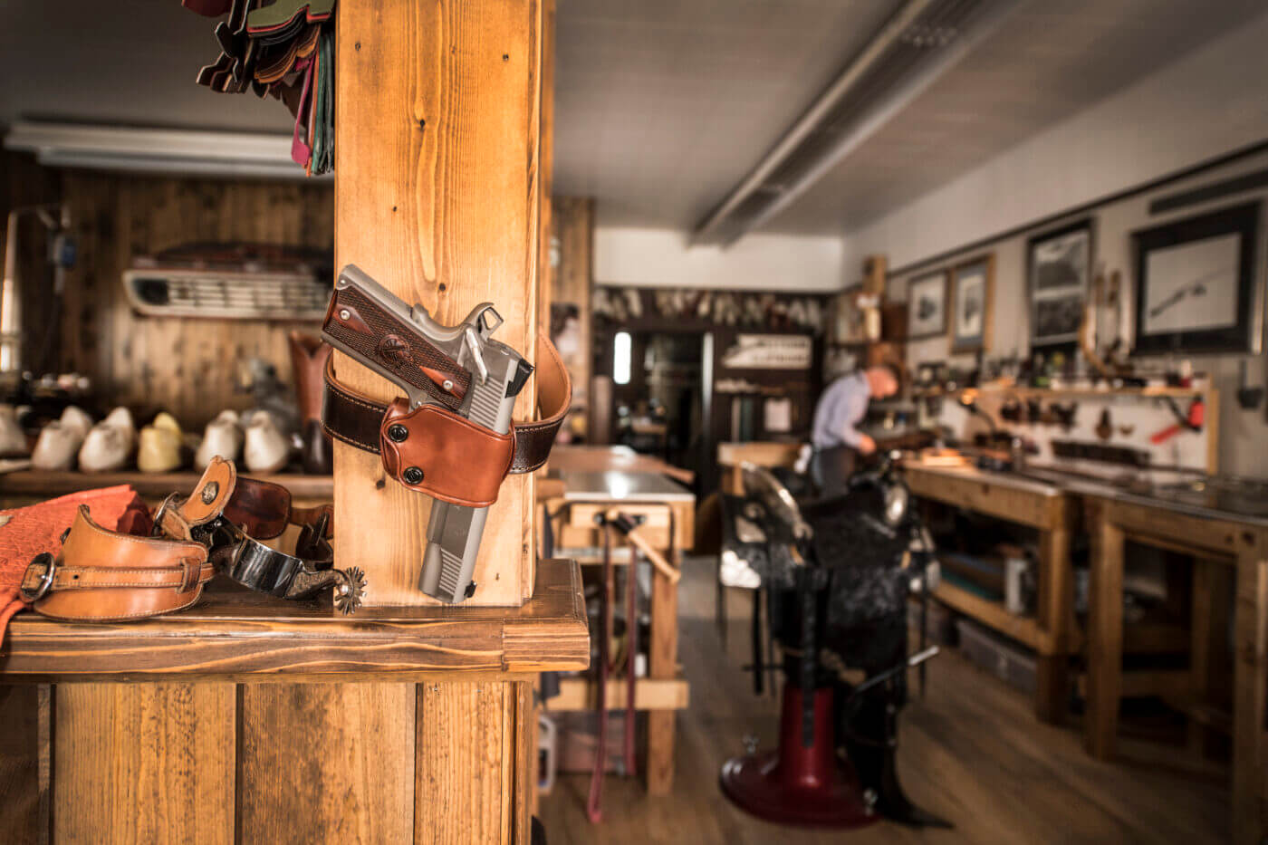 Gun in a holster hanging on wall in a workshop