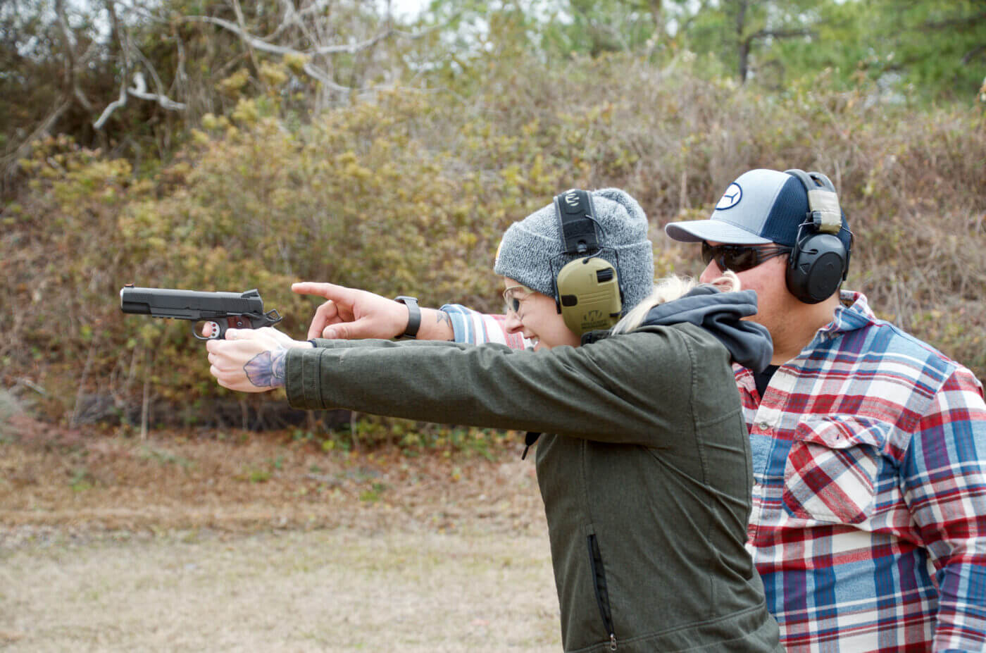 Man teaching a new shooter with a 1911 pistol