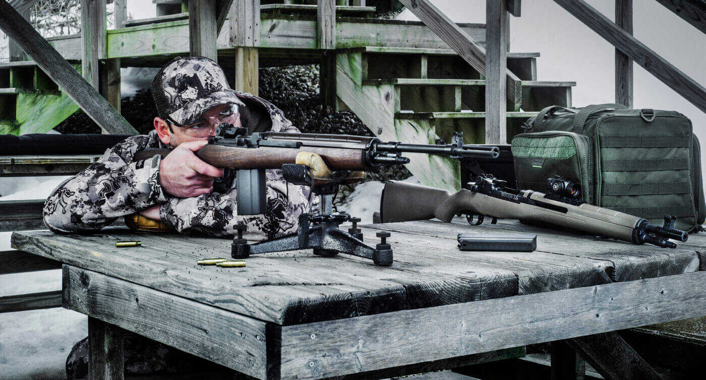 Man shooting rifle from test bench