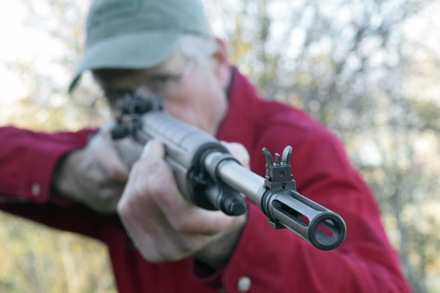 Man in red shirt holding a semi-automatic M1A rifle