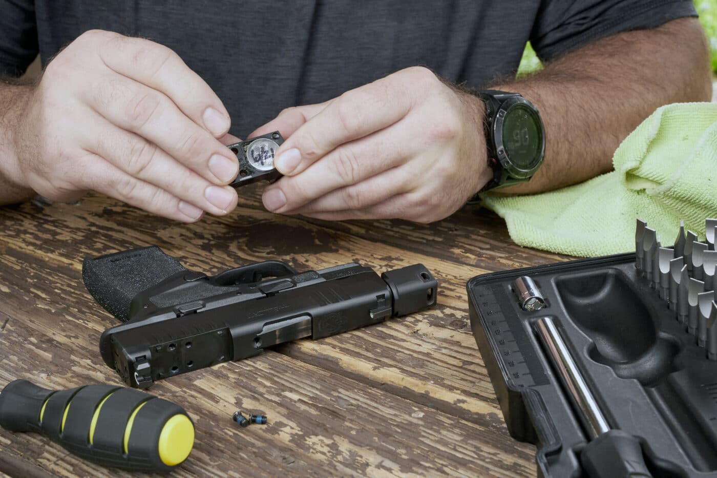 Man changing the battery on the HEX Wasp red dot