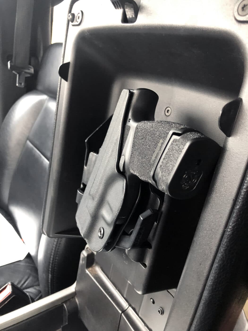 Springfield Hellcat pistol in a concealment holster inside a truck