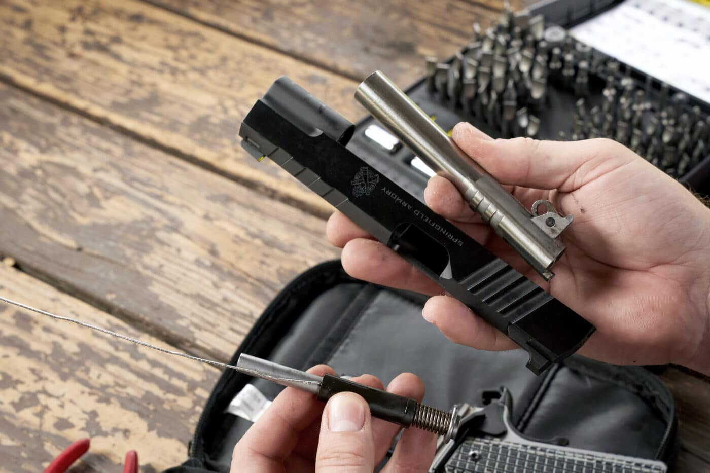 Man holding pieces of pistol after taking down the Emissary 1911 pistol