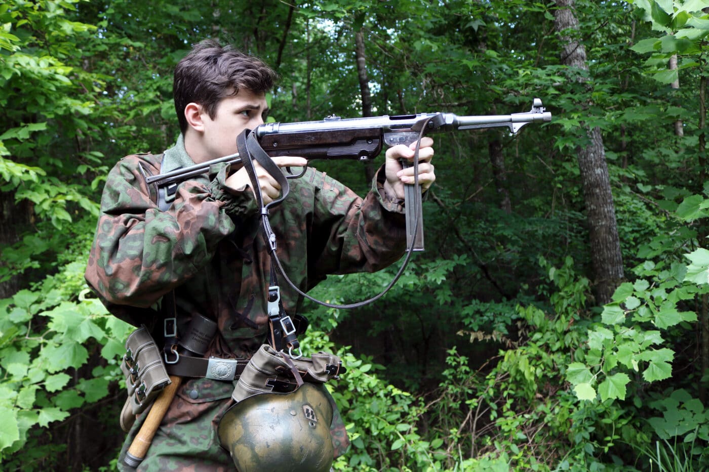 Man dressed as German SS soldier shooting an MP40 SMG