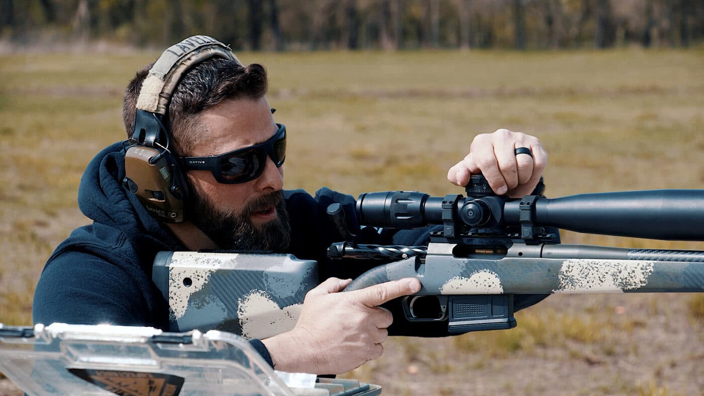 Man adjusting a scope while sighting it in