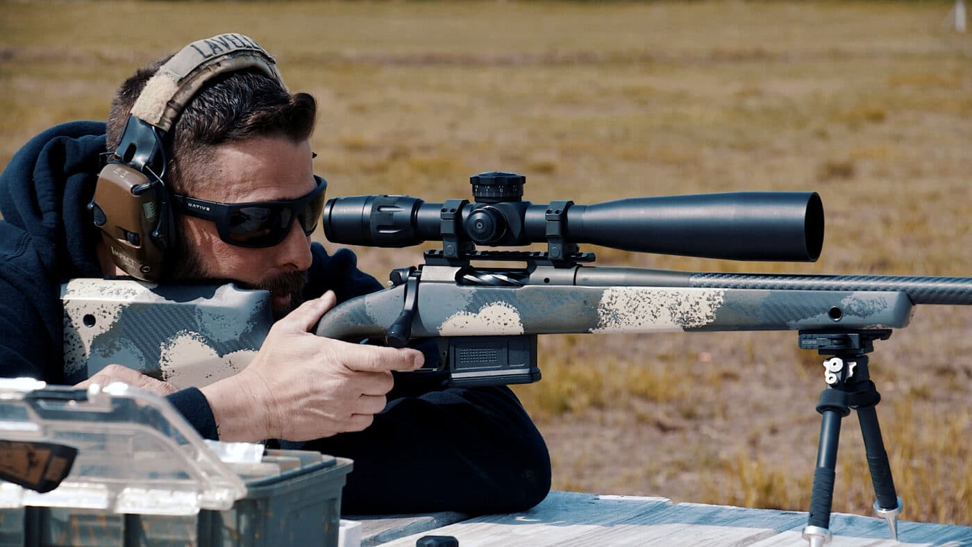 Man shooting a rifle while sighting it in at the range