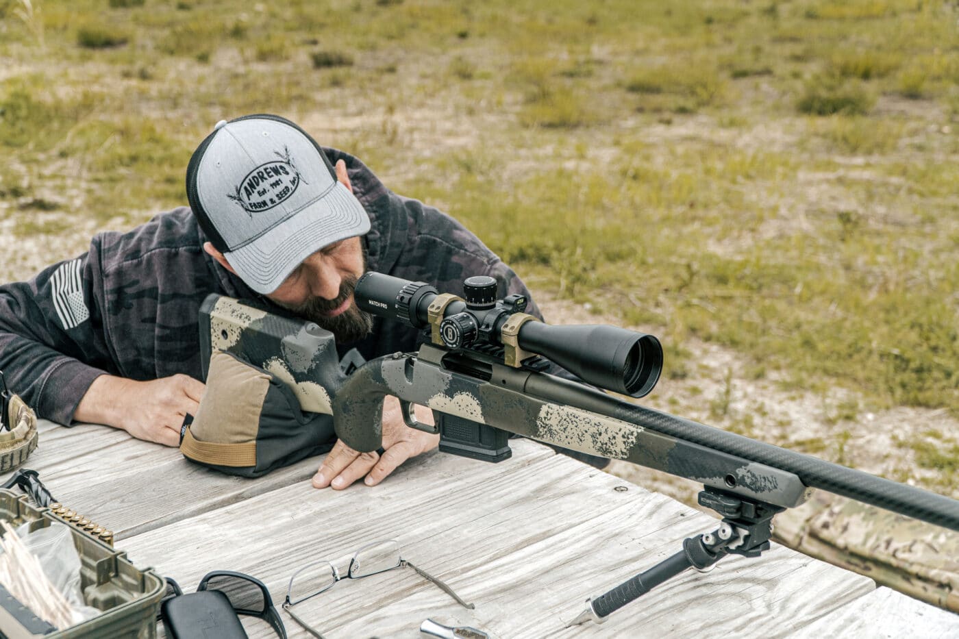 Man shooting a rifle at the range while sighting it in