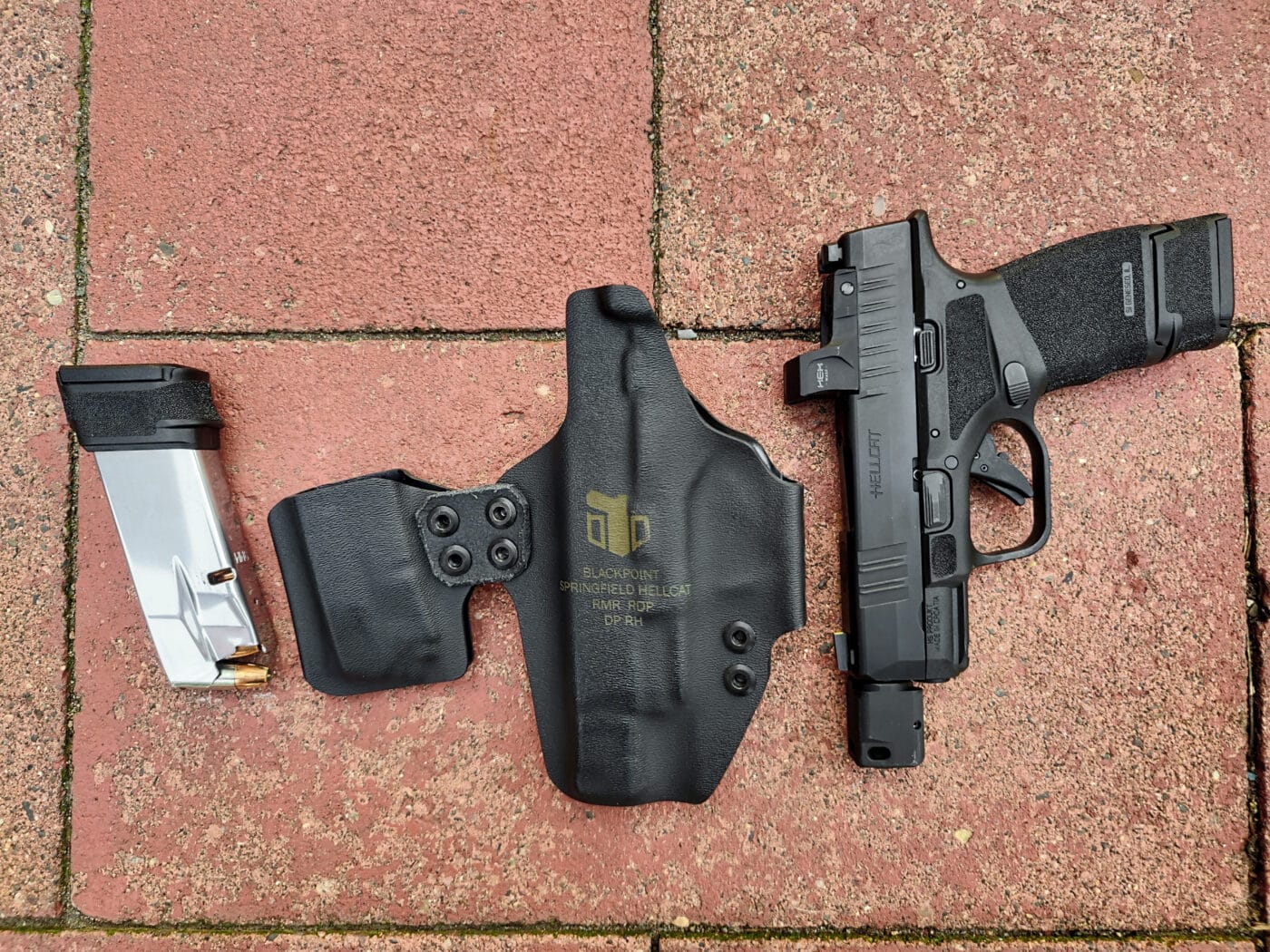 Hellcat pistol and magazine shown with DualPoint AIWB holster