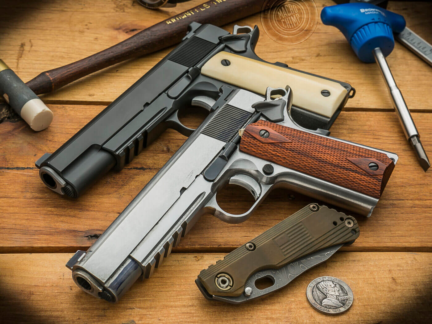 Custom built Springfield 1911 pistols on a table with tools