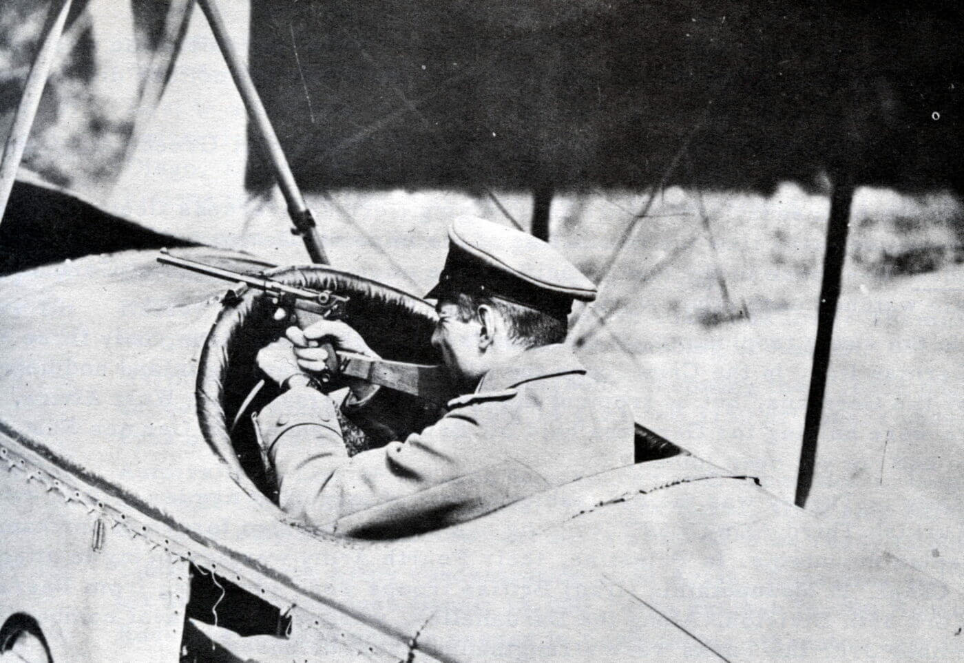 Luger being used by pilot in early airplane