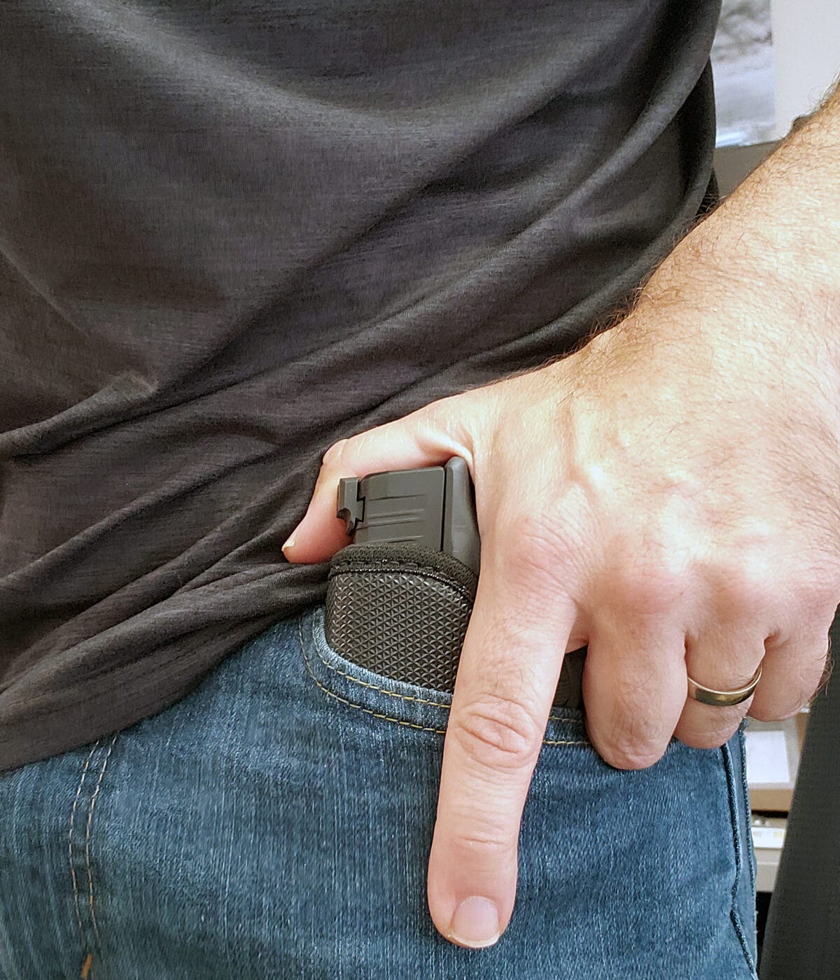 Man drawing Springfield Hellcat in Galco StukOn-U pocket holster from pocket