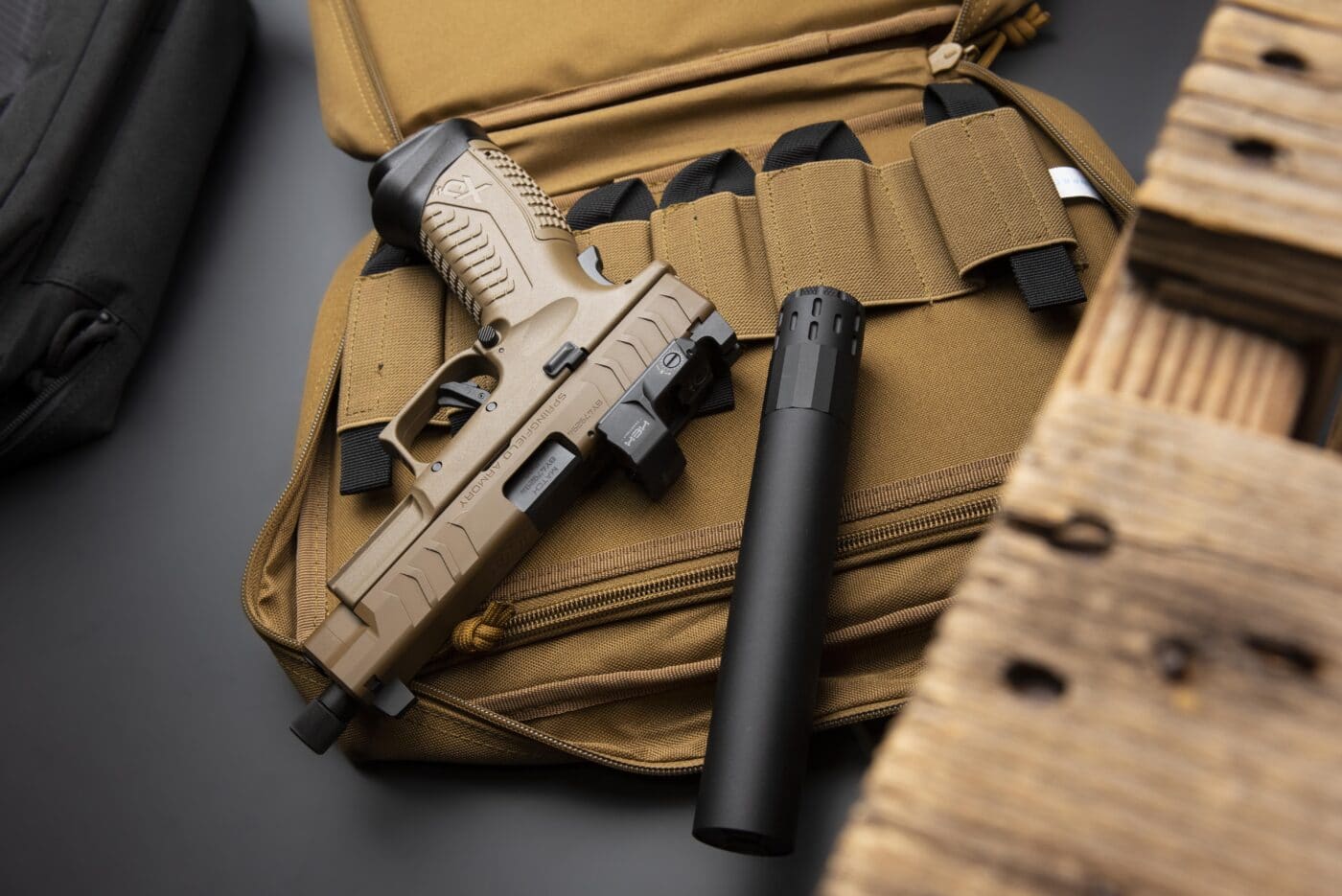 Multi-caliber suppressor sitting next to pistol