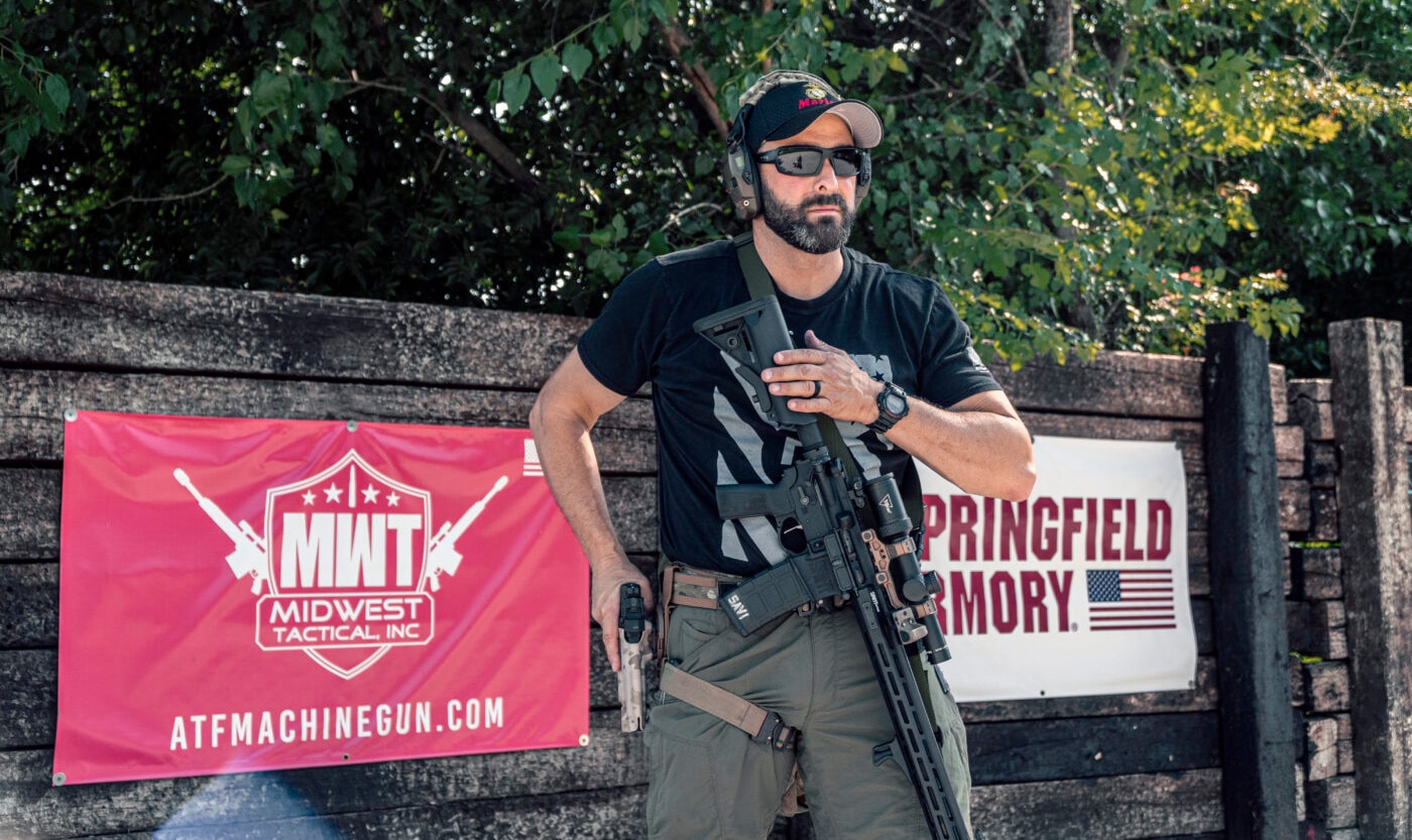 Man performing transition from rifle to pistol with three-point sling