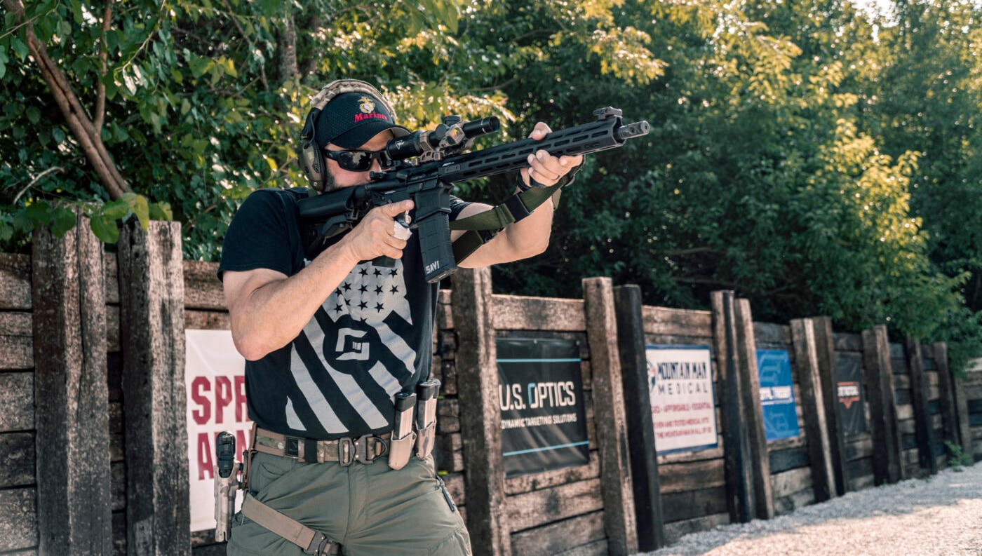 Man demonstrating the difficulty of shoulder transitions with a three-point rifle sling